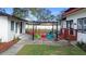 Backyard patio featuring pergola, colorful chairs, and view of garage at 1601 E 1St Ave, Mount Dora, FL 32757