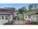 Backyard patio featuring pergola, colorful chairs, with view of house and garage at 1601 E 1St Ave, Mount Dora, FL 32757