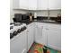 Compact kitchen with white cabinetry, black granite counters and modern appliances at 1601 E 1St Ave, Mount Dora, FL 32757