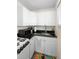 Compact kitchen features white cabinetry and black granite countertops at 1601 E 1St Ave, Mount Dora, FL 32757