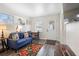 Bright living room featuring a comfortable blue sofa, vibrant floral rug, and natural light from two windows at 1601 E 1St Ave, Mount Dora, FL 32757