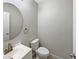 This bathroom features a modern sink, toilet, and round mirror at 1613 Reflection Cv, St Cloud, FL 34771