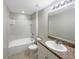 Clean bathroom with a shower-tub combo, tiled floors, and a vanity with granite countertop at 1613 Reflection Cv, St Cloud, FL 34771