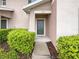 Inviting front entrance featuring a green door, lush greenery, and a welcoming walkway at 1613 Reflection Cv, St Cloud, FL 34771