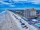 A scenic aerial shot showing a beachfront condo, sandy beach and blue ocean, perfect for relaxation at 1705 S Atlantic Ave # 402, New Smyrna Beach, FL 32169