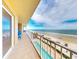 Spacious tiled balcony offering picturesque beach views and relaxing blue chairs at 1705 S Atlantic Ave # 402, New Smyrna Beach, FL 32169