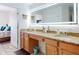 Modern bathroom with double sinks, wood cabinets, granite countertops, and ample lighting at 1705 S Atlantic Ave # 402, New Smyrna Beach, FL 32169