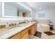 Bright bathroom featuring double sinks, granite countertops, and a large soaking tub at 1705 S Atlantic Ave # 402, New Smyrna Beach, FL 32169
