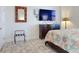 Bedroom features a large TV, decorative mirror, and seaside quilt on the bed at 1705 S Atlantic Ave # 402, New Smyrna Beach, FL 32169