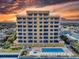 A low aerial view of a beachfront building with balconies, a pool, and a hot tub at 1705 S Atlantic Ave # 402, New Smyrna Beach, FL 32169