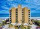 Stunning exterior view of a beachfront condo building featuring a large seashell emblem and multiple balconies at 1705 S Atlantic Ave # 402, New Smyrna Beach, FL 32169