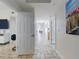 Bright hallway with tile floors leads to various rooms, showcasing the open layout and cohesive design elements at 1705 S Atlantic Ave # 402, New Smyrna Beach, FL 32169