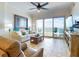 Light-filled living area featuring stylish furnishings, tile flooring, and sliding doors to the balcony with ocean views at 1705 S Atlantic Ave # 402, New Smyrna Beach, FL 32169
