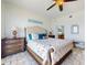 Bright bedroom featuring a tufted headboard bed, tiled floors, and a view into the ensuite bathroom at 1705 S Atlantic Ave # 402, New Smyrna Beach, FL 32169