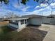 View of the backyard of this home including the rear of the home and a screened in patio area at 1826 Giles St, Deltona, FL 32725