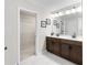Bathroom with dual sinks, a large mirror, modern fixtures, and a walk-in closet at 1856 Cross Prairie Pkwy, Kissimmee, FL 34744