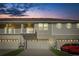 Beautiful townhome featuring a two-car garage and a second-story balcony at dusk at 1856 Cross Prairie Pkwy, Kissimmee, FL 34744