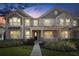 Inviting two-story home with lush landscaping, an attractive front door and large windows at 1856 Cross Prairie Pkwy, Kissimmee, FL 34744