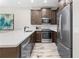 Bright kitchen featuring stainless steel appliances, dark wood cabinets, and quartz countertops at 1856 Cross Prairie Pkwy, Kissimmee, FL 34744