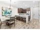 Stylish kitchen and dining area featuring stainless appliances, a breakfast bar, and modern lighting at 1856 Cross Prairie Pkwy, Kissimmee, FL 34744