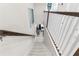 Staircase featuring white and wood railings, leading down into a beautifully decorated living space at 1856 Cross Prairie Pkwy, Kissimmee, FL 34744