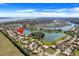 Stunning aerial view of a lakeside community featuring beautiful homes and lush landscaping under a clear blue sky at 1950 Windward Oaks Ct, Kissimmee, FL 34746