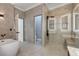 Bathroom showcasing the soaking tub, glass shower, and adjoining water closet and linen closet at 1950 Windward Oaks Ct, Kissimmee, FL 34746