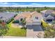 An inviting two-story home with a tile roof and a three-car garage is situated with views of a tranquil lake at 1950 Windward Oaks Ct, Kissimmee, FL 34746
