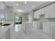 Spacious kitchen boasts marble floors, island, and white cabinetry at 1950 Windward Oaks Ct, Kissimmee, FL 34746