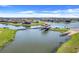 Beautiful aerial view of homes along a lake, featuring a boat dock with a lift and scenic waterways at 1950 Windward Oaks Ct, Kissimmee, FL 34746