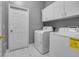 Laundry room includes a white washer and dryer with overhead cabinets at 1950 Windward Oaks Ct, Kissimmee, FL 34746