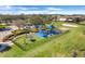 Aerial view of a fenced playground with colorful equipment, picnic tables, and lush green surroundings at 1950 Windward Oaks Ct, Kissimmee, FL 34746