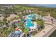 Aerial shot of community pool with beach entry, splash pad, slide, and mature landscaping at 1950 Windward Oaks Ct, Kissimmee, FL 34746