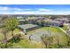 Aerial view of tennis and basketball courts surrounded by lush landscaping in a residential community at 1950 Windward Oaks Ct, Kissimmee, FL 34746