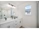 Modern bathroom featuring dual sinks, white cabinets, sleek black fixtures, and a large mirror at 1987 Peel Ave, Orlando, FL 32806