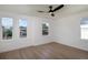 Bright bedroom with hardwood floors, ceiling fan, and plenty of natural light from multiple windows at 1987 Peel Ave, Orlando, FL 32806