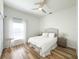 Bright bedroom features light colored wood-look floors, ceiling fan, and crisp, neutral bedding at 2121 Knollview Ct, Oviedo, FL 32765