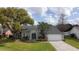 Charming home featuring lush landscaping, arched windows, and a well-maintained lawn and a two-car garage at 2121 Knollview Ct, Oviedo, FL 32765