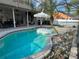 A shell floaty in a screened-in pool with an umbrella and a grill nearby at 2121 Knollview Ct, Oviedo, FL 32765