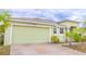 Exterior view of the home featuring a light green garage door and pastel green exterior at 2608 Sunset Cir, Lake Wales, FL 33898