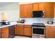 Bright kitchen featuring stainless steel appliances, wooden cabinetry, and a white tiled backsplash at 2608 Sunset Cir, Lake Wales, FL 33898