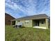 Spacious backyard featuring a covered patio, green grass, and a partial fence at 2668 Spider Lily Ct, Clermont, FL 34711