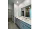 Modern bathroom featuring double vanities, a large mirror, and a separate shower at 2668 Spider Lily Ct, Clermont, FL 34711