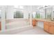 Inviting bathroom with a tub, glass block window, and vanity at 2932 Bayhead Run, Oviedo, FL 32765