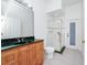 Stylish bathroom with a green marble countertop, wood cabinets, a glass-enclosed shower, and white tile floor at 2932 Bayhead Run, Oviedo, FL 32765