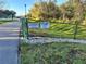 Community signage posted along path, with a green fence, greenery, and small rocks on the grounds at 2932 Bayhead Run, Oviedo, FL 32765