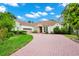 Stunning single-story home boasts an expansive brick driveway, lush landscaping, and a two-car garage at 2932 Bayhead Run, Oviedo, FL 32765