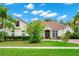 Elegant home featuring manicured landscaping, a beautiful lawn, and a welcoming brick entrance at 2932 Bayhead Run, Oviedo, FL 32765