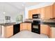 Bright kitchen features granite counters, black appliances, and neutral backsplash at 2932 Bayhead Run, Oviedo, FL 32765