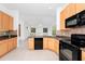 Bright kitchen features granite counters, black appliances, and tile backsplash at 2932 Bayhead Run, Oviedo, FL 32765